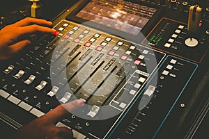 Close up of technical hand with music mixer equalizer console for mixer control sound device.