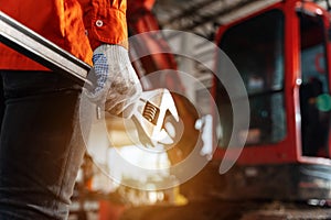 Close up of A technician hand holding a tool for maintenance or machine service in the workshop. Heavy Duty Equipment Maintenance