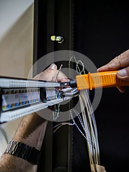 Technician hands installing network cables in server rack