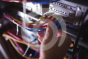 Close-Up of technician plugging patch cable in a rack mounted server