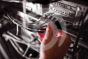Close-Up of technician plugging patch cable in a rack mounted server