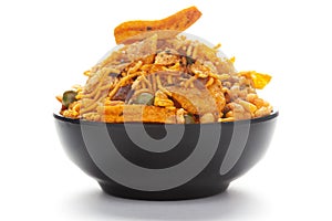 Close up of Teekha Meetha crunchy spicy Indian namkeen snacks on a ceramic black bowl