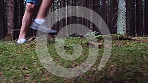 close-up of a teen boy's feet walking in the forest in summer day, walk in the woods