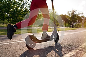 Close up of teen riding electric kick scooter