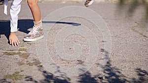 Close-up. teenage girl legs in pink shiny sneakers. girl is making a gymnastic exercise, a cartwheel