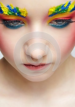 Close-up teenager girl face portrait with face art make-up . Paint on brows