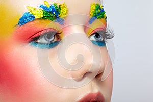 Close-up of teenager girl portrait with unusual face art make-up with paint on brows