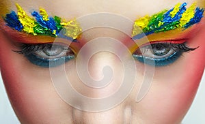 Close-up of teenager girl portrait with unusual face art make-up with paint on brows