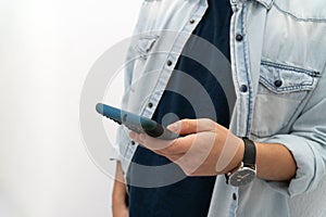 Close-up of a teenager`s hands using a smart phone on a white background