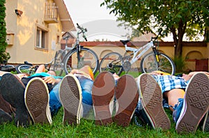 Close up of teenagers feet in sneakers while lying on the grass