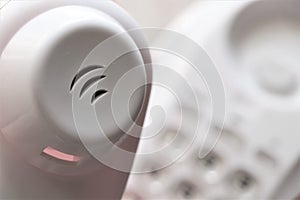 Close up of a telephone handset with a red led, and the keypad in the background.