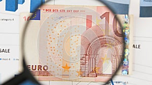 Close-up of ten euros through a magnifying glass. Business background. Money research concept