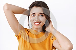 Close-up tender, feminine alluring young stylish caucasian woman in yellow t-shirt, holding hands behind as mend her