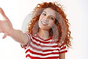 Close-up tender feminine curly redhead woman blue eyes tilting head posing striped t-shirt stretch arm towards hold