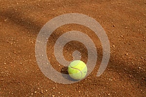 Close up of tennis ball on clay court. Tennis ball on a tennis clay court. Red clay tennis court