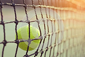 Close up tennis ball hitting to net on background