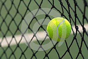 Close up tennis ball hitting to net on background