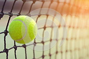 Close up tennis ball hitting to net on blur background