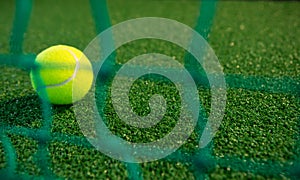 Close up of tennis ball seen through net