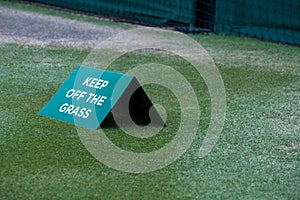 Close up of tennis court at Wimbledon, with sign saying `keep off the grass` photographed during the 2018 championships.