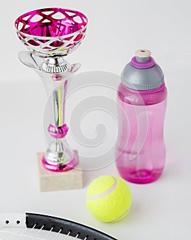 Close up of tennis racket, ball, cup and bottle