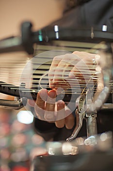 Close up of tennis stringer hands doing racket stringing