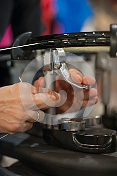 Close up of tennis stringer hands doing racket stringing