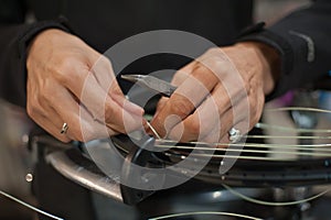 Close up of tennis stringer hands doing racket stringing photo