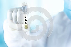 Close up a test tube in the hand of a doctor from the scientific laboratory, a concept of drug use to treat and protect the global