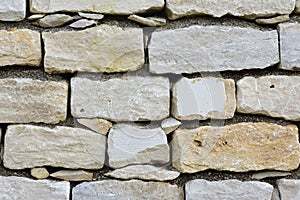 Close up and texture of a bright stone wall with joints