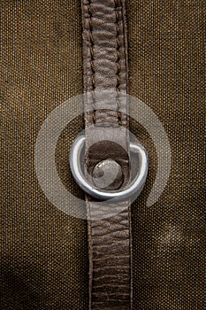 Close-up texture of a canvas fabric backpack. Leather straps and metal buckles. Vintage khaki back