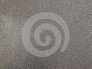 Close-up texture of a rough, sandy brown wall surface.