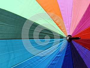 Colorful beach umbrella background, close-up texture of vibrant color nylon fabric parasol with concentric radius pattern