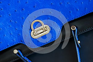 Close-up texture of vivid fashion blue color handbag, genuine leather with embossed under the skin of Ostrich, gold lock