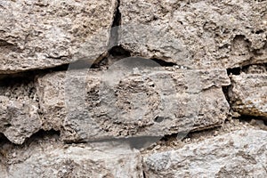 Close-up textured background is an irregular natural stone wall made of different stones without a cement-type bonding