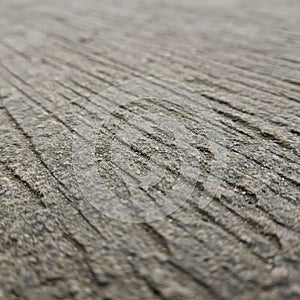 Close-up of textured concrete with parallel grooves running across the surface. The