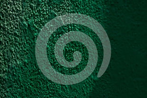 Close-up of textured green wall surface with shadows