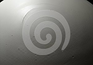 Close-up of a textured grey surface with a semi-circular shape. The