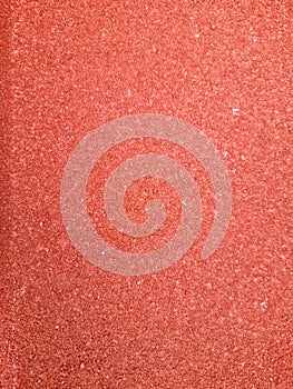 Close-up of a textured red surface, resembling fine grains or tiny crystals photo