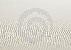 Close-up of a textured surface featuring parallel, diagonal lines. The material appears