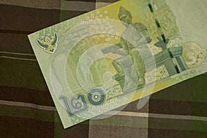 Close up of Thai banknote Thai bath with the image of Thai King. Thai banknote of 20 Thai baht on Green Scottish fabric.