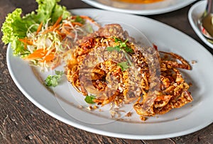 Close up Thai food image, deep-fried soft shell crab with garlic on wooden table, crispy deep-fried soft shell crab with garlic.