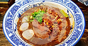 Close up Thai noodle with Australian Wagyu beef, stewed pork, meatball, liver and blood soup on bowl.