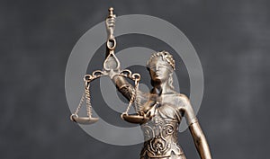 close up themis is goddess of justice statuette on dark background. symbol of law with scales