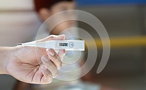 Close-up thermometer. Father measuring temperature of his ill kid. Hand on forehead