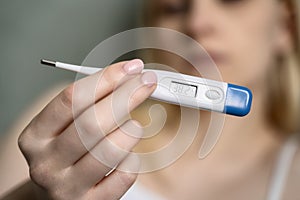 Close-up thermometer. Mother measuring temperature of her ill kid.