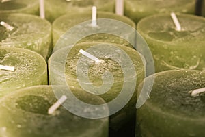 Close-up of thick green wax candles in shop. Warehouse of handmade scented candles