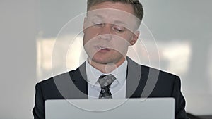 Close Up of Thinking Businessman Working on Laptop, Frontal View
