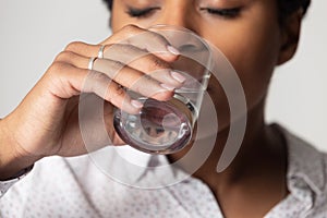 Close up of thirsty biracial female drinking pure water
