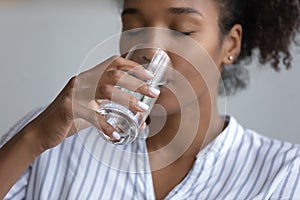 Close up of thirsty biracial woman drink water